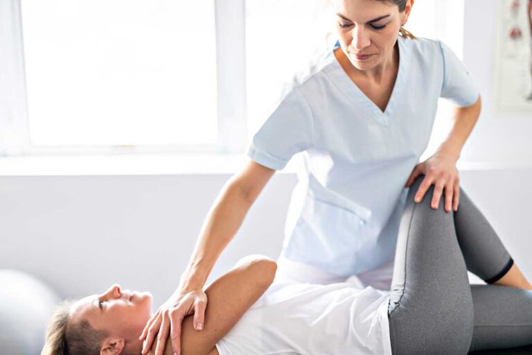 A chiropractor carefully performing a spinal adjustment on a patient lying on a treatment table.
