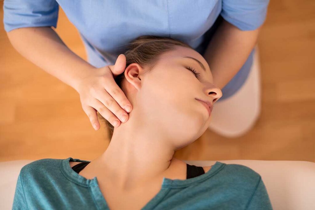 Patient discusses a treatment plan with a chiropractor in a bright clinical examination room.